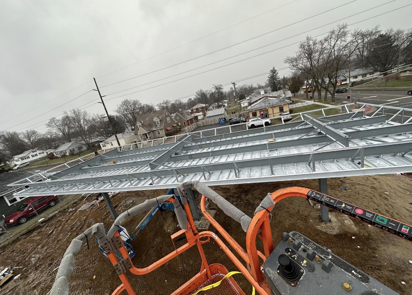 Steel canopy structure site work from a lift basket